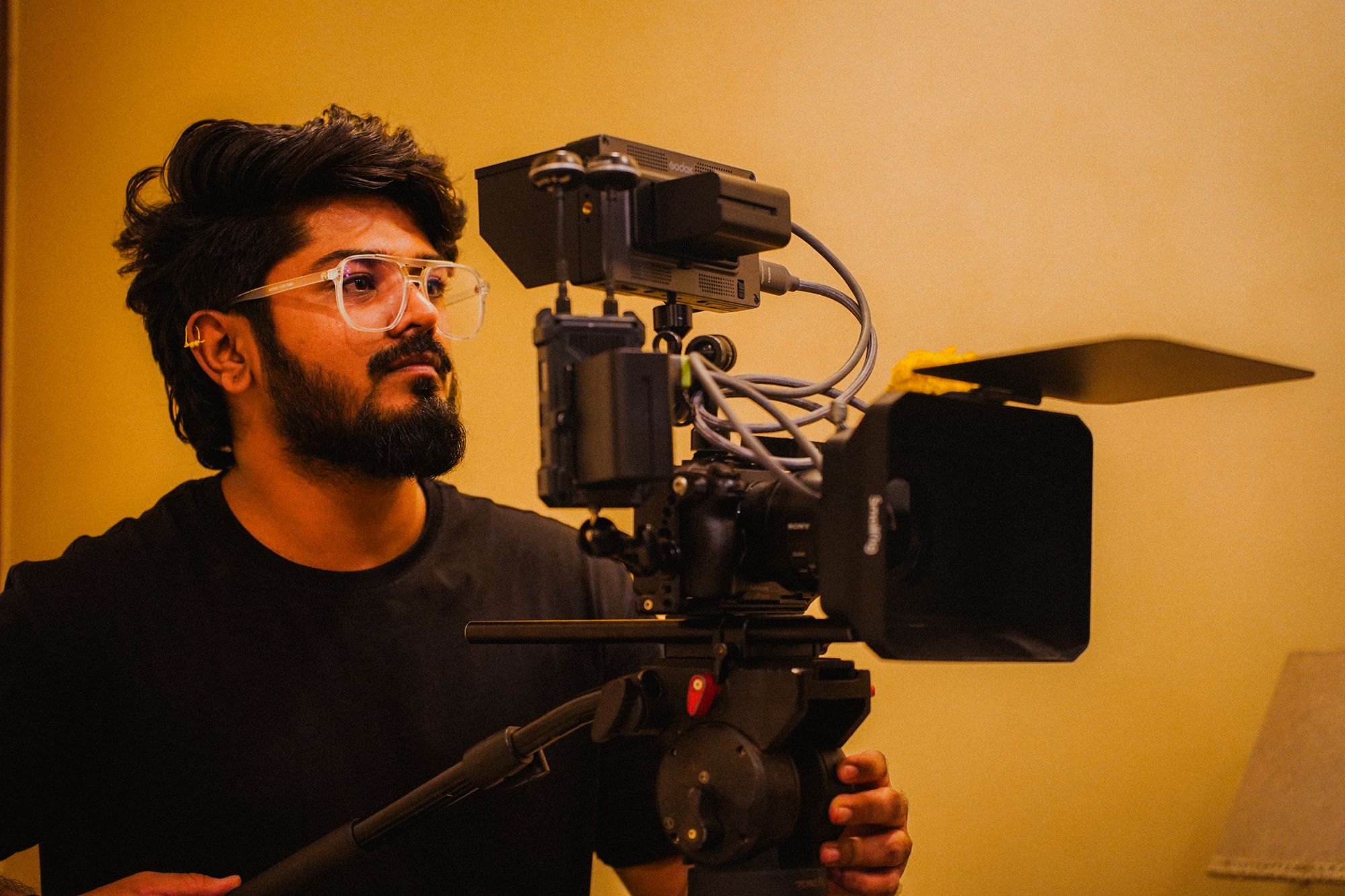 Raghvendra Joshi on set, framing a shot behind a rigged cinema camera