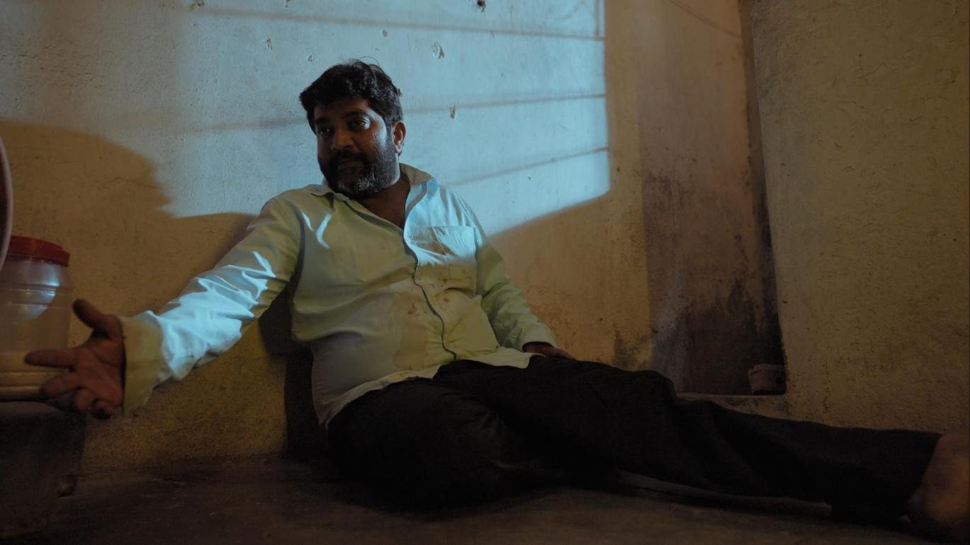 Happy Birthday: a man slumped on the floor under cold blue light