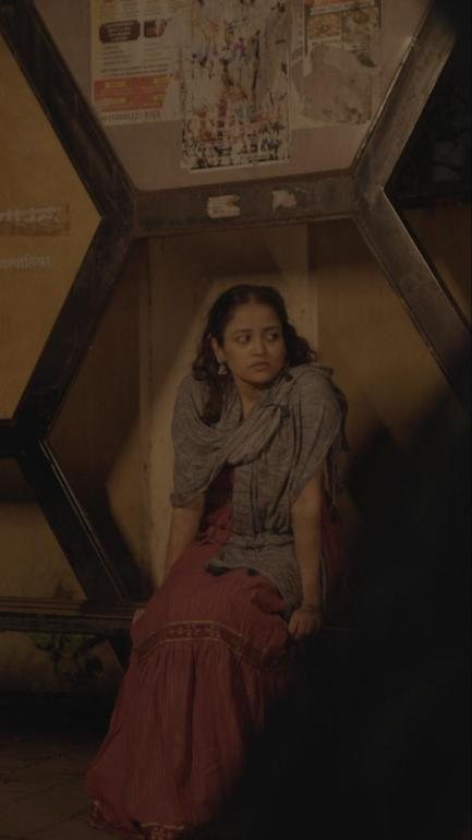 Two Spoons Full: a woman waits alone at a bus stop at night