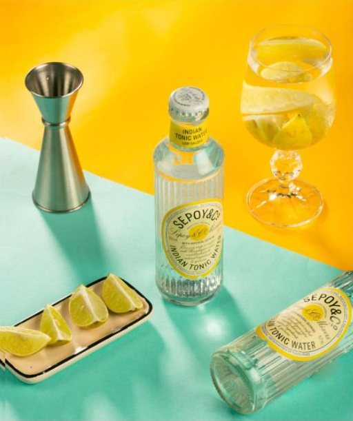 Tonic water and lime on yellow and teal